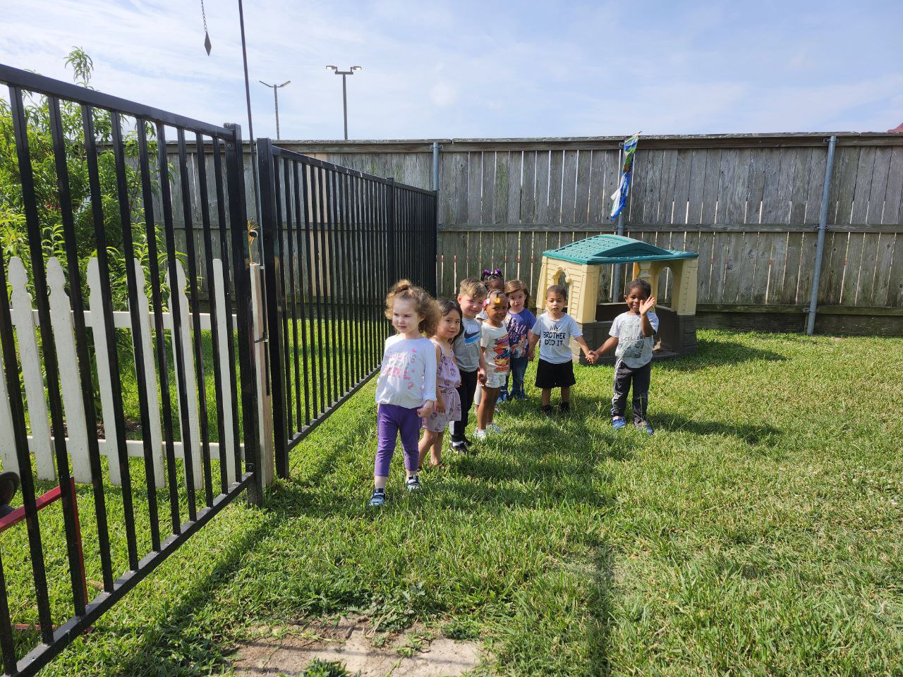 Children holding hands outside on a playground.