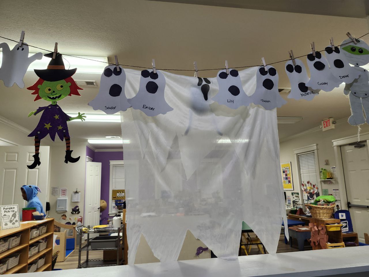 A daycare room with a bunch of ghosts, a witch, and a mummy decorations.