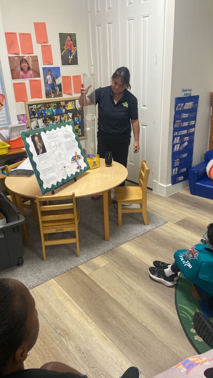 The Science Lady presenting a poster board to the class.